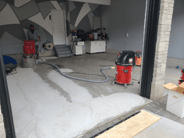 Worn concrete garage floor being ground and resurfaced in a Hamilton, Ontario home
