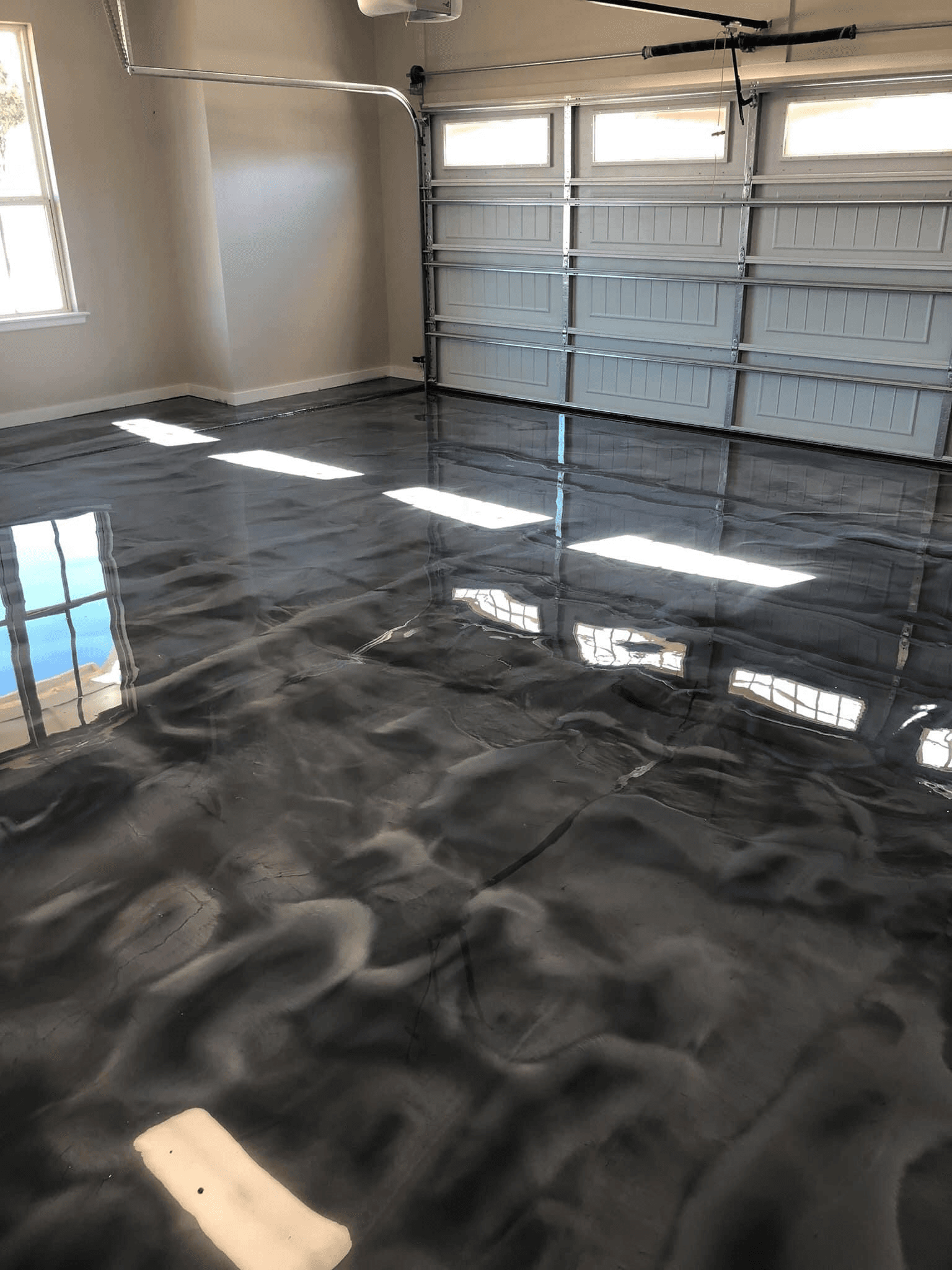 High-gloss metallic silver polymer floor coating finished in a two-car garage in Hamilton, Ontario