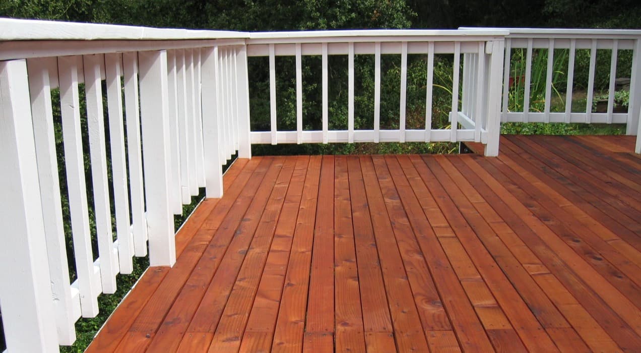 White railing and wooden deck professionally stained by Bay City Painters in Hamilton, Ontario